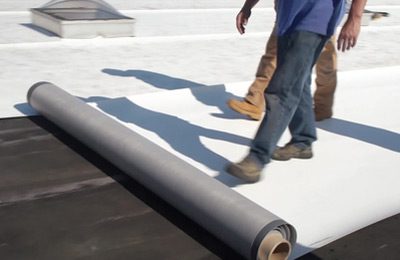Roofers repairing a commercial roof