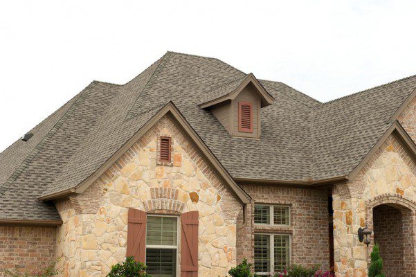 A stone house is pictured with a brand new roof