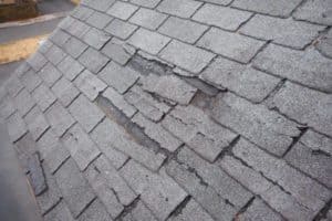 A roof with shingles that have been cracked and broken by hail