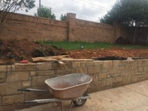 The construction of an immaculate stone retaining wall.