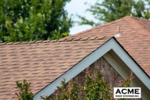 Close-up of a new roof with the Acme Roof Systems logo.