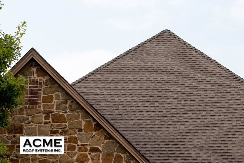 Close-up of a new roof with the Acme Roof Systems logo.