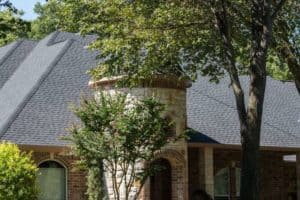 Close-up of a new roof on a beautiful house with nice landscaping.