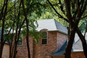 Close-up a new roof on a two-story red brick home.
