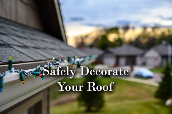 A roof with beautiful Christmas lights on the gutter along with the words, safely decorate your roof.