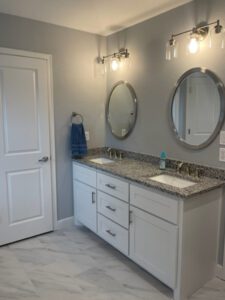 a white vanity with two sinks and two mirrors