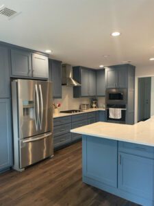 a remodeled kitchen with blue cabinets and white countertops